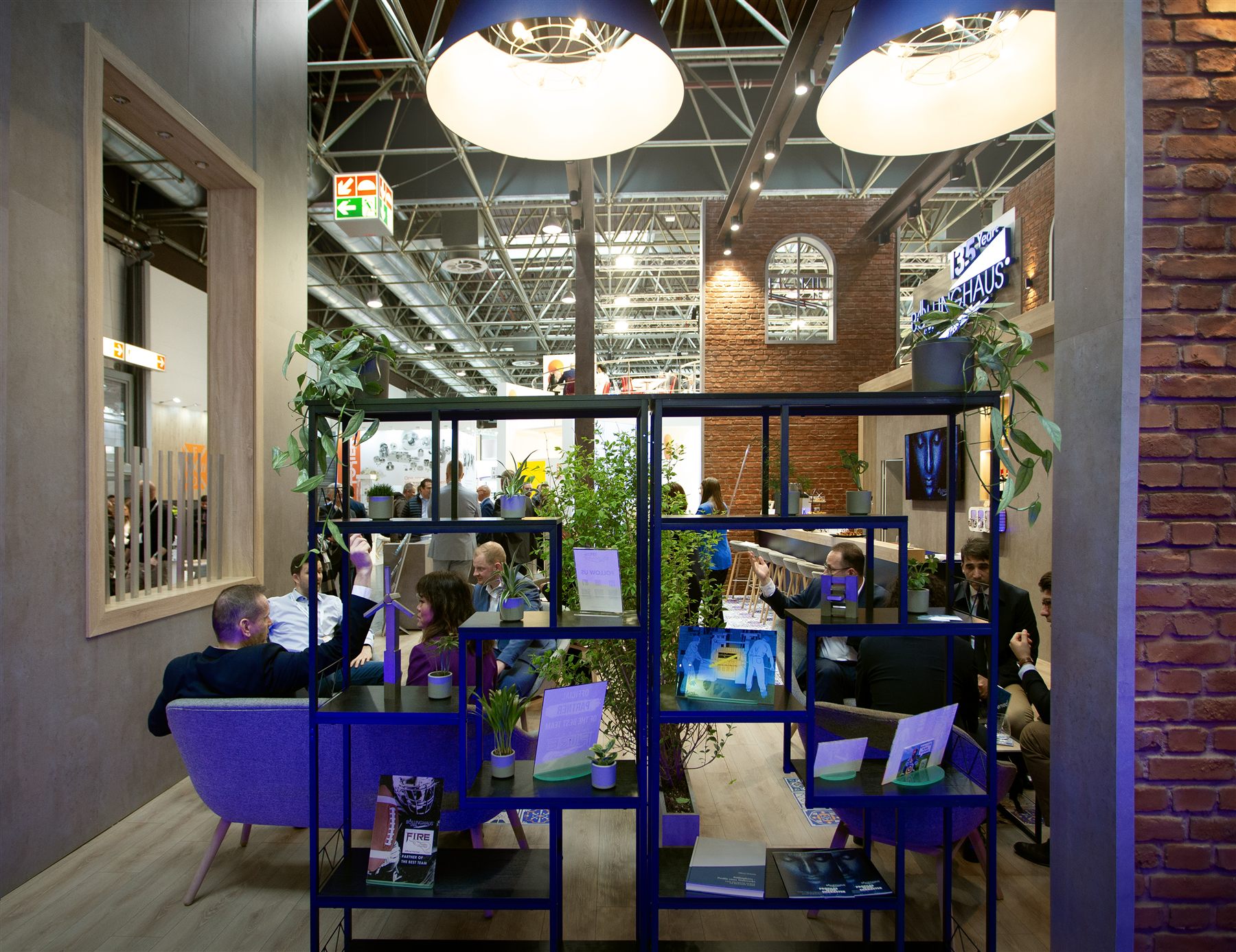 Loungebereich am Böllinghaus-Stand auf der Wire 2024 mit Backstein und Messinglicht